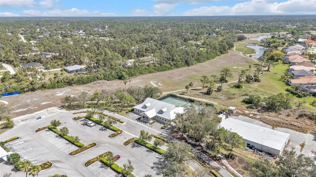 birds eye view of property featuring a water view and a wooded view