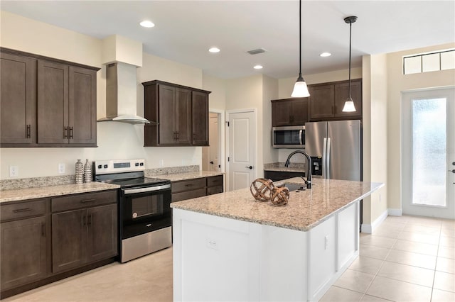 kitchen with a sink, visible vents, dark brown cabinets, wall chimney range hood, and appliances with stainless steel finishes