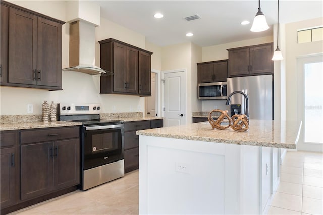 kitchen with dark brown cabinetry, visible vents, wall chimney exhaust hood, appliances with stainless steel finishes, and light stone countertops