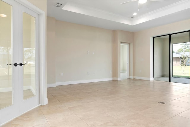 unfurnished room featuring visible vents, baseboards, ornamental molding, a tray ceiling, and french doors