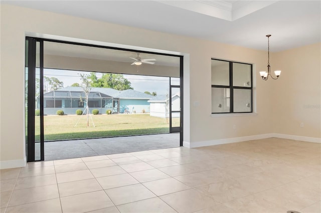 tiled empty room featuring baseboards and an inviting chandelier