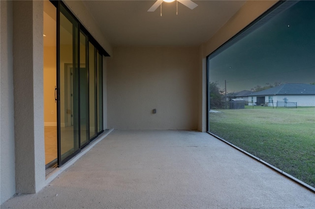 unfurnished sunroom with ceiling fan