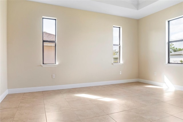 spare room with baseboards and light tile patterned floors