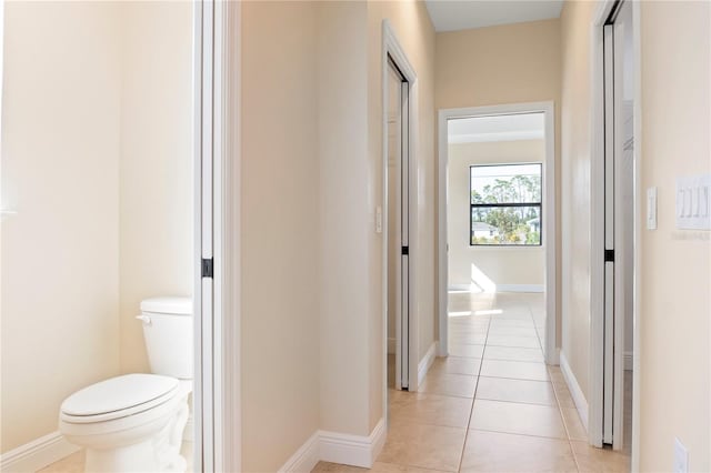 hallway with light tile patterned floors and baseboards