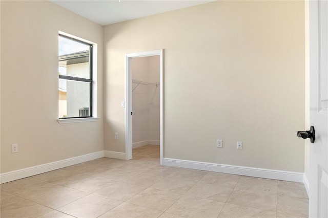 spare room featuring baseboards and light tile patterned floors