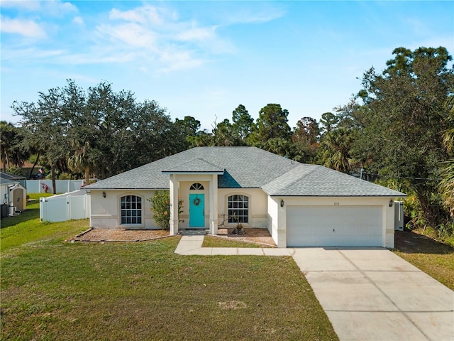 ranch-style home with an attached garage, fence, concrete driveway, stucco siding, and a front yard