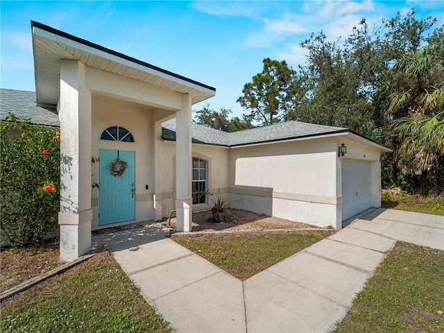 exterior space with concrete driveway, roof with shingles, an attached garage, a front lawn, and stucco siding