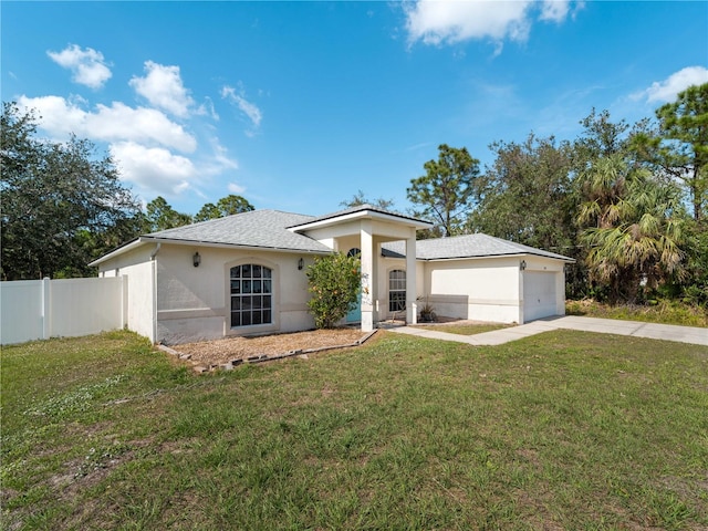 view of front of house with an attached garage, fence, driveway, stucco siding, and a front lawn