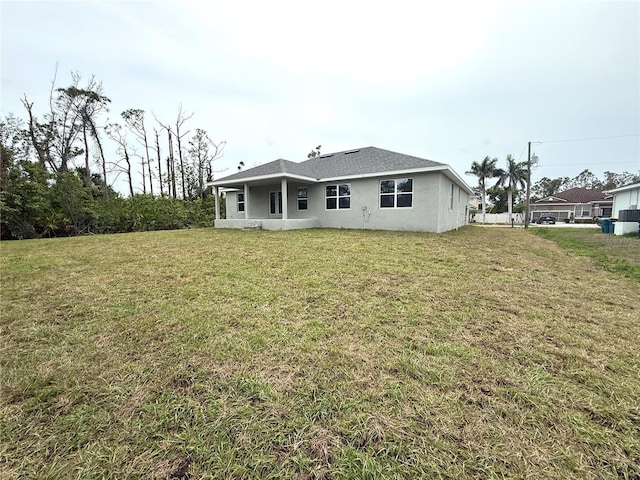 9590 Little Rock St, Port Charlotte, FL 33981 - rear view of property featuring stucco siding and a yard