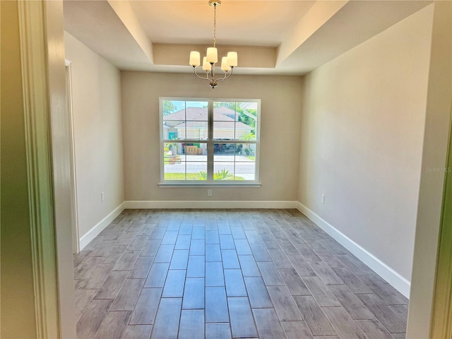 9590 Little Rock St, Port Charlotte, FL 33981 - empty room featuring a raised ceiling, a chandelier, and wood tiled floors