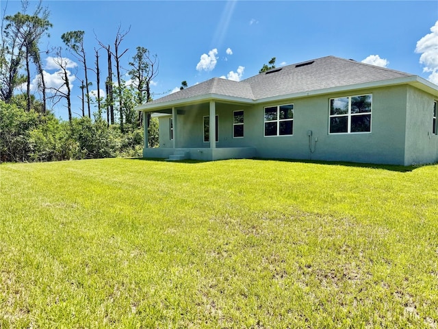 9590 Little Rock St, Port Charlotte, FL 33981 - back of property with stucco siding, a yard, and roof with shingles