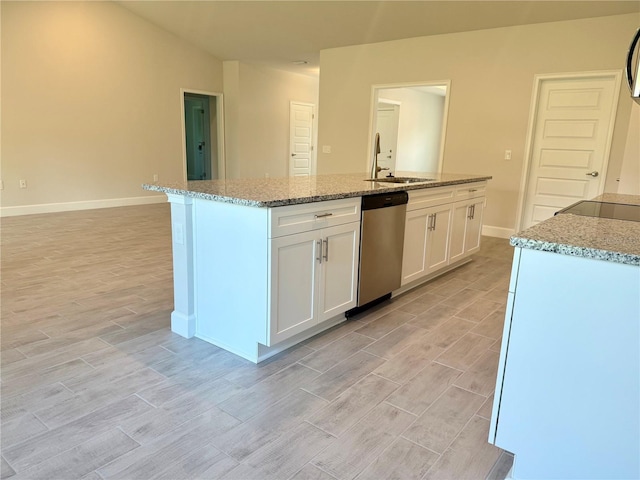 9590 Little Rock St, Port Charlotte, FL 33981 - kitchen featuring stainless steel dishwasher, light wood-style flooring, white cabinets, and an island with sink