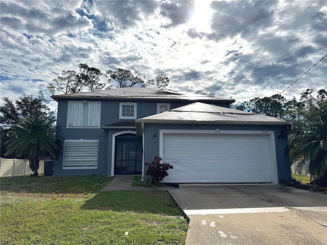 traditional-style home featuring a garage, driveway, a front lawn, and stucco siding