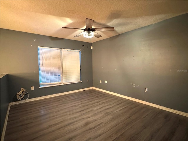 spare room featuring dark wood-style floors, ceiling fan, a textured ceiling, and baseboards