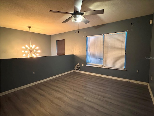 spare room with dark wood finished floors, a textured ceiling, baseboards, and ceiling fan with notable chandelier