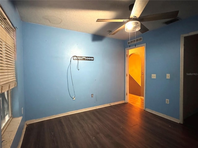 unfurnished bedroom with baseboards, visible vents, ceiling fan, and dark wood-type flooring