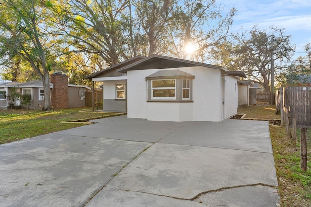 view of front facade featuring a front lawn, fence, and stucco siding