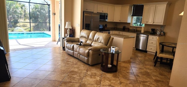 kitchen featuring appliances with stainless steel finishes, a breakfast bar area, light tile patterned flooring, and a kitchen island