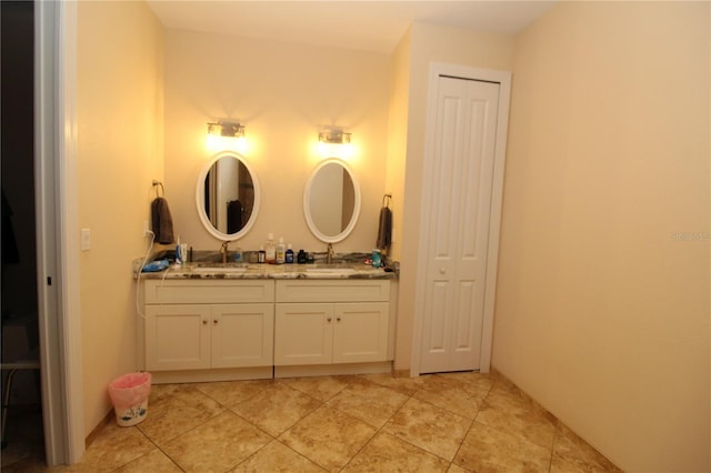 full bathroom featuring a sink, double vanity, a closet, and tile patterned floors