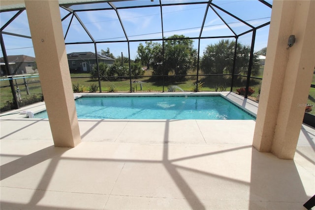 outdoor pool with glass enclosure and a patio