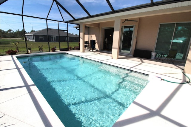 outdoor pool with a ceiling fan, a lanai, and a patio area