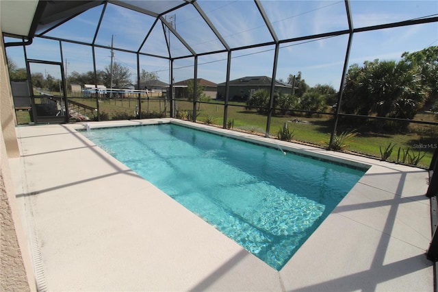 pool with glass enclosure and a patio