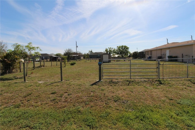 view of yard featuring a storage unit, a gate, and fence