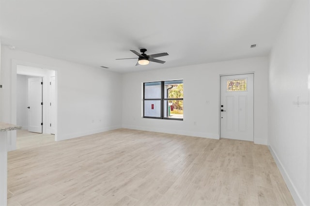 unfurnished living room featuring a ceiling fan, baseboards, visible vents, and light wood finished floors