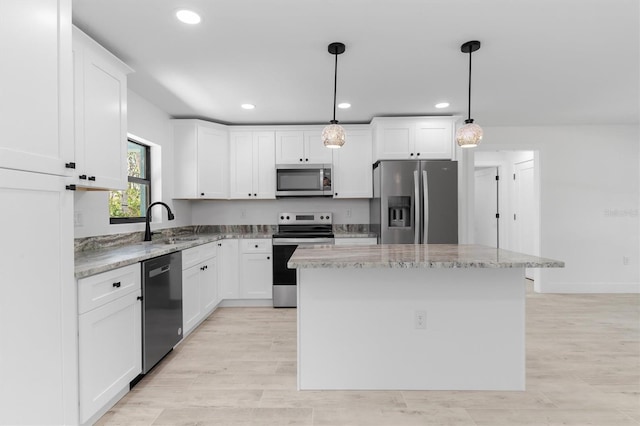 kitchen featuring a kitchen island, white cabinetry, and stainless steel appliances