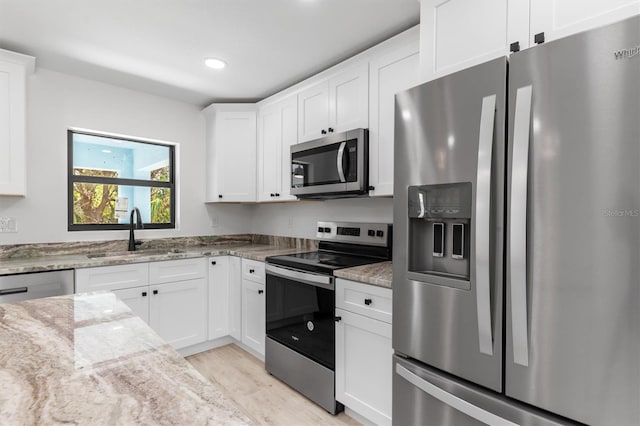 kitchen with stainless steel appliances, white cabinets, and a sink