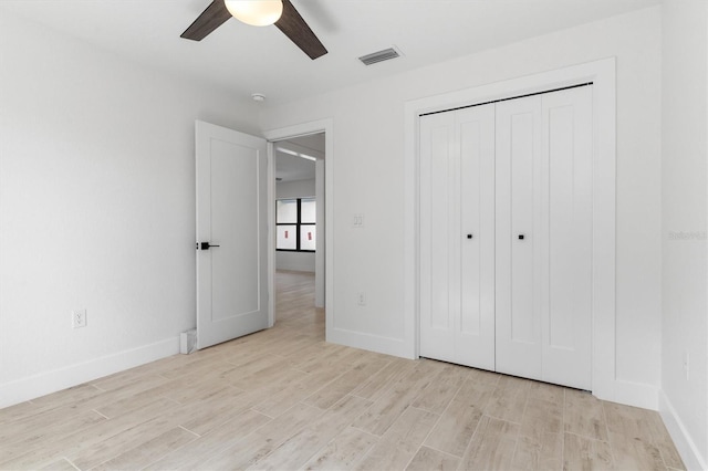 unfurnished bedroom with a closet, visible vents, light wood-style flooring, and baseboards