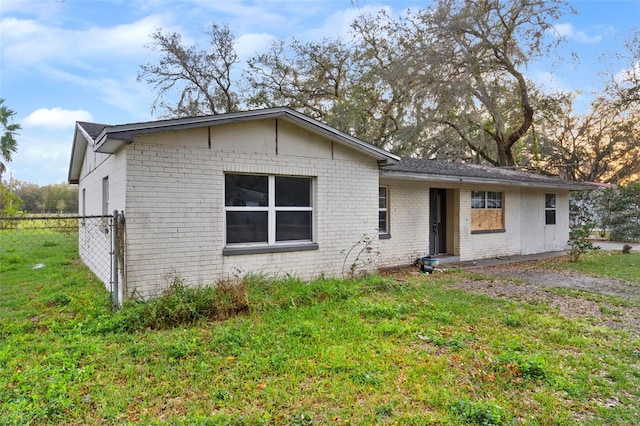 view of front of home with a front yard, brick siding, and fence