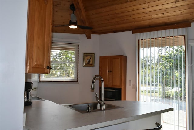 kitchen with plenty of natural light, wood ceiling, light countertops, and a sink