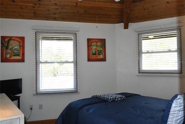 bedroom with beam ceiling, multiple windows, and wooden ceiling