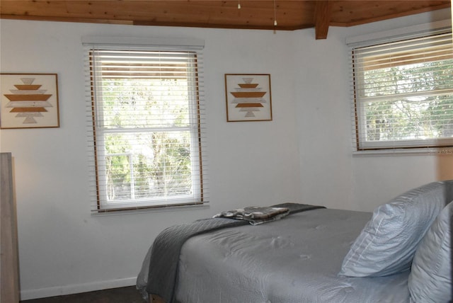 bedroom featuring multiple windows, wooden ceiling, and baseboards