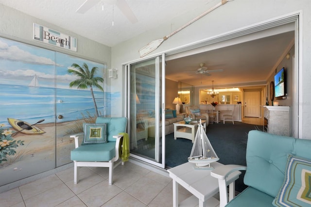 sunroom featuring ceiling fan with notable chandelier