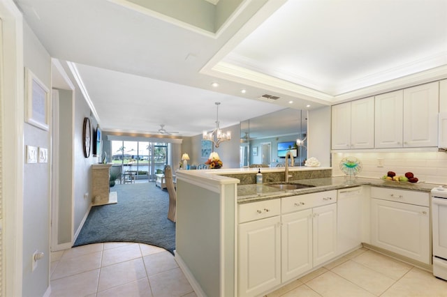 kitchen with a peninsula, white appliances, open floor plan, and crown molding