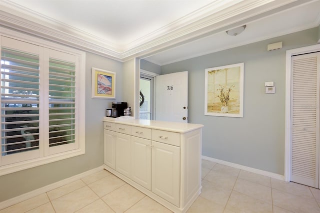 interior space featuring ornamental molding, light countertops, baseboards, and light tile patterned floors