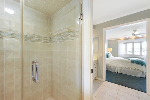 ensuite bathroom with crown molding, a ceiling fan, a stall shower, ensuite bath, and tile patterned flooring