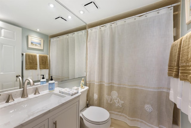 bathroom featuring toilet, vanity, visible vents, and recessed lighting