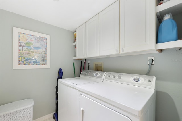 laundry room with cabinet space, independent washer and dryer, and baseboards