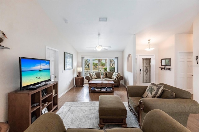 living area with lofted ceiling, visible vents, baseboards, a ceiling fan, and dark wood-style floors