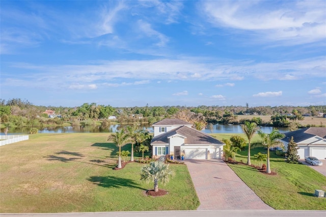 view of front of house with a water view, a garage, a front lawn, and decorative driveway