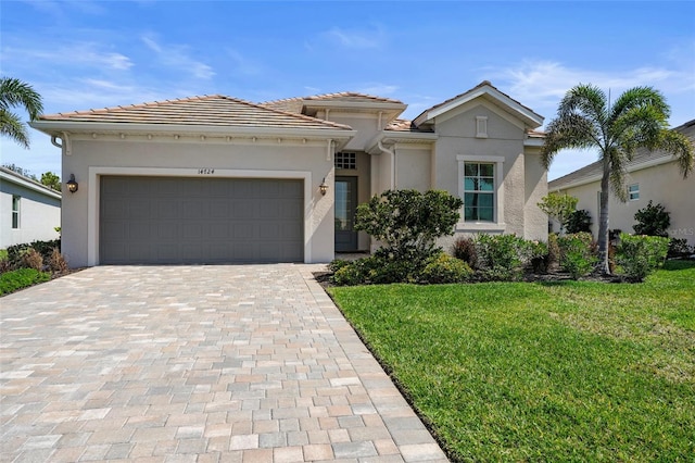 view of front of home featuring a garage, a front yard, decorative driveway, and stucco siding