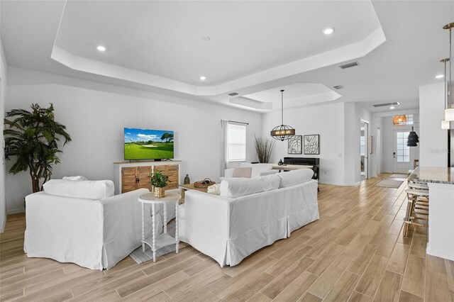 14724 Cherry Blossom Way, Punta Gorda, FL 33955 - living area featuring plenty of natural light, visible vents, a tray ceiling, and wood finish floors