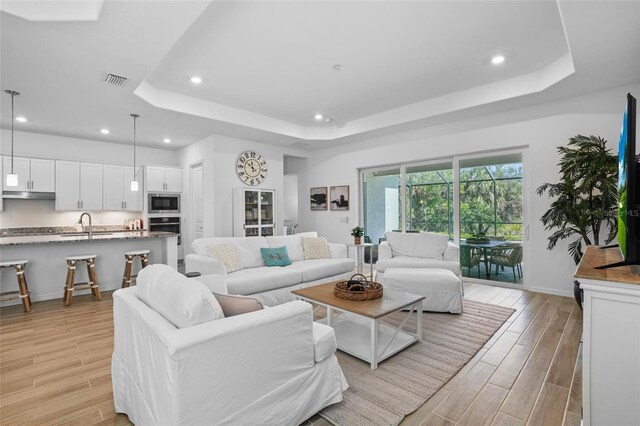 14724 Cherry Blossom Way, Punta Gorda, FL 33955 - living area featuring a tray ceiling, wood finish floors, recessed lighting, visible vents, and baseboards