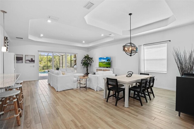14724 Cherry Blossom Way, Punta Gorda, FL 33955 - dining space featuring baseboards, a tray ceiling, visible vents, and light wood-style floors