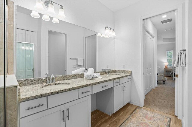 14724 Cherry Blossom Way, Punta Gorda, FL 33955 - full bathroom featuring wood finish floors, visible vents, a sink, and double vanity