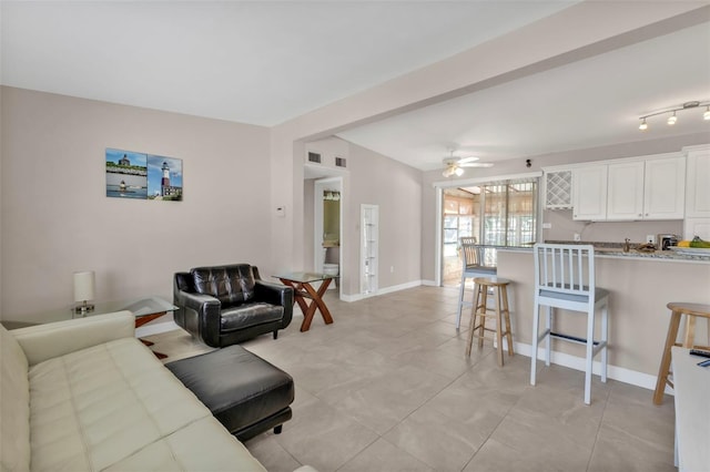 living area with visible vents, ceiling fan, and baseboards