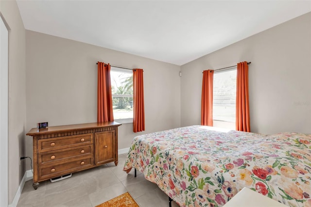 bedroom featuring light tile patterned floors and baseboards